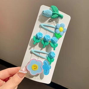 Détail d'un lot de 6 barrettes à fleurs en résine bleu et vert sur carte blanche