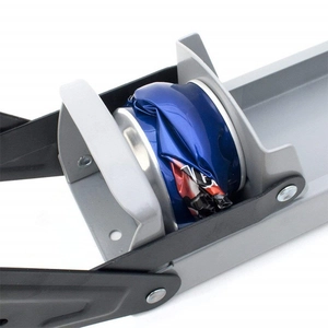 Wall-mounted metal can crusher with black handle crushing a blue soda can on white background