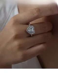 Vue détaillée de la bague coeur en argent avec zircons étincelants sur un doigt