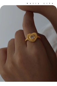 Détail d'une bague coeur dorée vintage avec relief texturé et incrustation de zircon