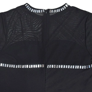 Detail of black mesh dress featuring elegant rhinestone trim and sheer panel design