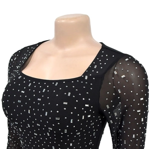 Detail of square neckline with rhinestones and sheer mesh sleeves on a black dress