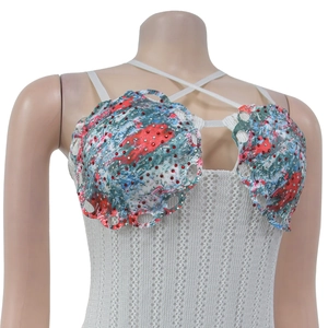 Detail of white crochet dress with red rhinestone shell accents and cross-neck straps