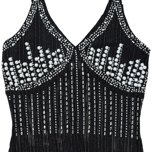 Close-up of deep V-neck black dress featuring white pearls and shimmering rhinestones
