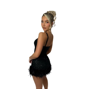 Close-up of sparkling black sequins and soft feather trim on a sexy mini cocktail dress
