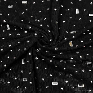 Macro shot of black mesh fabric with sparkling rhinestones and sequins detailing