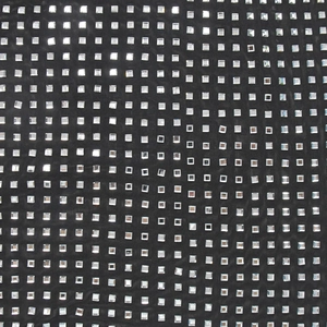 Dettaglio del tessuto a rete nero con paillettes argentate per abito da sera donna con scollo a V