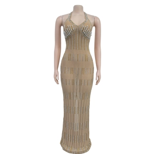Close-up of elegant V-neck dress with white pearls and gold rhinestones on nude mesh