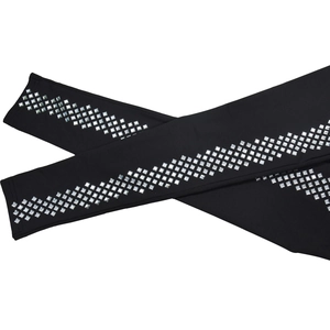 Detail of black dress sleeve with diagonal rows of square silver rhinestones on knit fabric