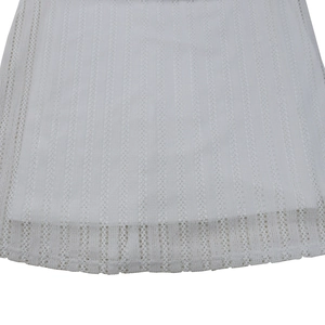 Detailed macro view of white crochet lace hem and vertical striped texture on the dress