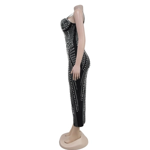 Dettaglio delle perle bianche su un abito nero attillato con decorazioni in strass chic