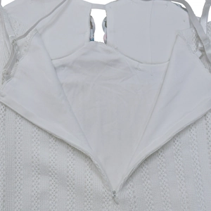 Detail of white lace dress showing adjustable thin straps and invisible zipper closure