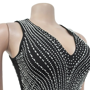 Close-up of sparkling rhinestones and vertical pattern on a black sleeveless V-neck dress