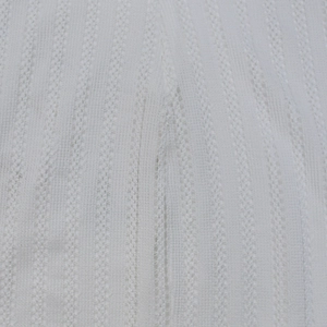 Macro detail of white lace knit fabric with vertical stripes and hollow out texture