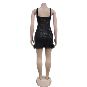 Detail of black sequined mini dress featuring feathers on the hem and a back zipper