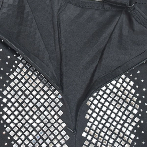 Detail of black V-neck dress featuring silver square rhinestones and front zipper closure