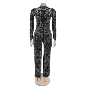 Detail of black jumpsuit showing intricate white rhinestone wavy patterns and high neck