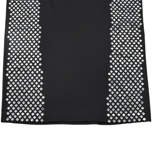 Macro shot of silver square sequins on black long sleeve dress with high slit detail