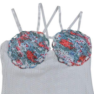 Detail of white lace camisole dress with colorful graffiti print and sequin embellishments