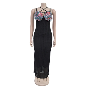 Detail view of black knit halter maxi dress featuring vibrant floral crochet shell patterns