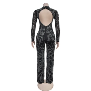 Detail of backless black jumpsuit with long sleeves and silver rhinestone wave patterns
