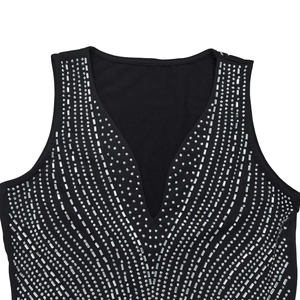 Detail of deep V-neckline with sparkling rhinestones and silver sequins on black fabric