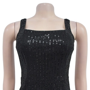 Detail of black sequined camisole dress with white embroidered lettering on the chest