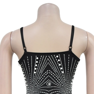 Dettaglio del retro di un top nero con motivi geometrici in strass e perle lucide