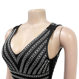 Close-up of black V-neck dress with intricate silver rhinestones and square studs detail