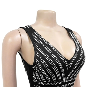 Detail of deep V-neckline on black dress featuring intricate silver rhinestone patterns