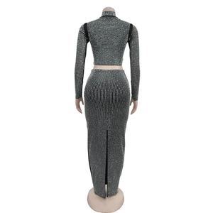 Detailansicht eines strassbesetzten schwarzen Crop-Tops und passenden Schlitzrocks am Torso