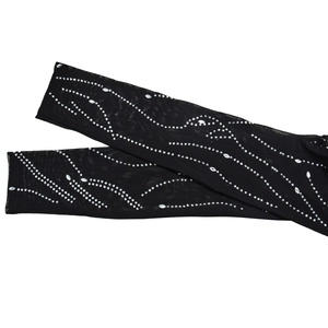 Detail of black mesh jumpsuit sleeves with silver rhinestones in a wave pattern