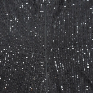 Macro detail of shimmering black sequins on mesh fabric with a seamless hidden zipper