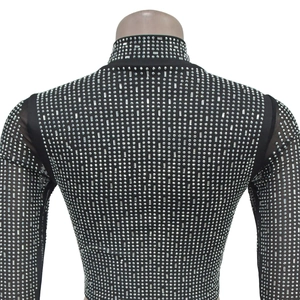 Details von silbernen Strasssteinen und Pailletten auf schwarzem Mesh-Kleid mit Ärmeln