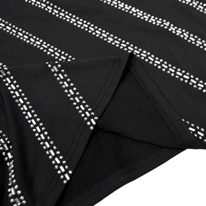 Detail of multi-row rhinestone embellishments on the hem of a black sleeveless dress