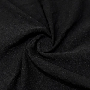 Macro shot of black knitted fabric texture with elegant drapes and soft touch