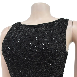 Close-up of black sequined evening dress fabric featuring high-shine texture and round neck