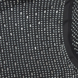 Detail aus schwarzem elastischem Stoff mit silbernen Strasssteinen und Netznaht