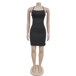 Détail d'une mini robe noire avec une silhouette ajustée et des carrés en strass partout