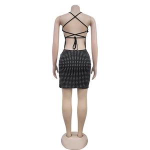 Détail de la robe courte dos nu avec bretelles croisées et motifs de pois en strass