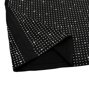 Detail of black dress hem featuring silver rhinestones and a side slit finish