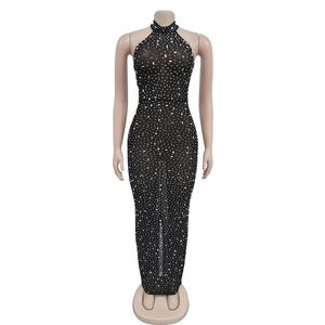 Macro detail of sheer mesh fabric with shimmering rhinestones on a black evening gown