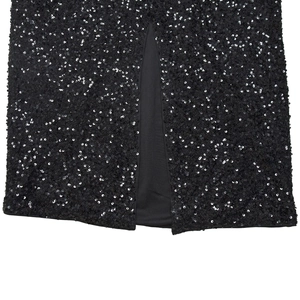 Detailed macro view of black sequined dress featuring a high-quality center hem slit design