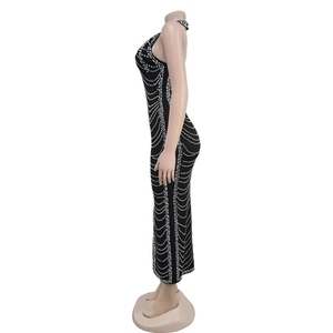 Detail of black bodycon maxi dress with shimmering rhinestone wave patterns and halter neck