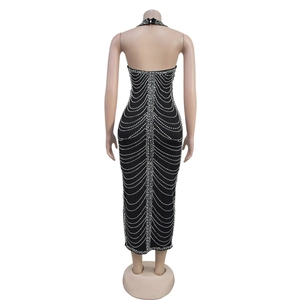 Detail of rhinestone wave patterns on a black backless halter dress showing back texture