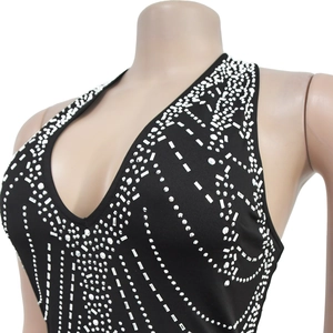 Close-up of sparkling silver rhinestones on a sexy black V-neck sleeveless dress fabric