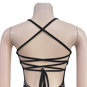 Detail of black backless dress featuring intricate criss-cross straps and rhinestone trim