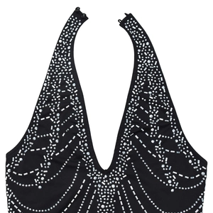Detail showing the halter neck closure with buttons and rhinestone patterns on the black dress