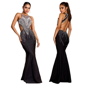 Close-up of black backless mermaid dress with silver rhinestones and cut-out waist detail