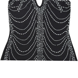 Detail of deep V-neck black dress featuring decorative silver rhinestones and metallic studs